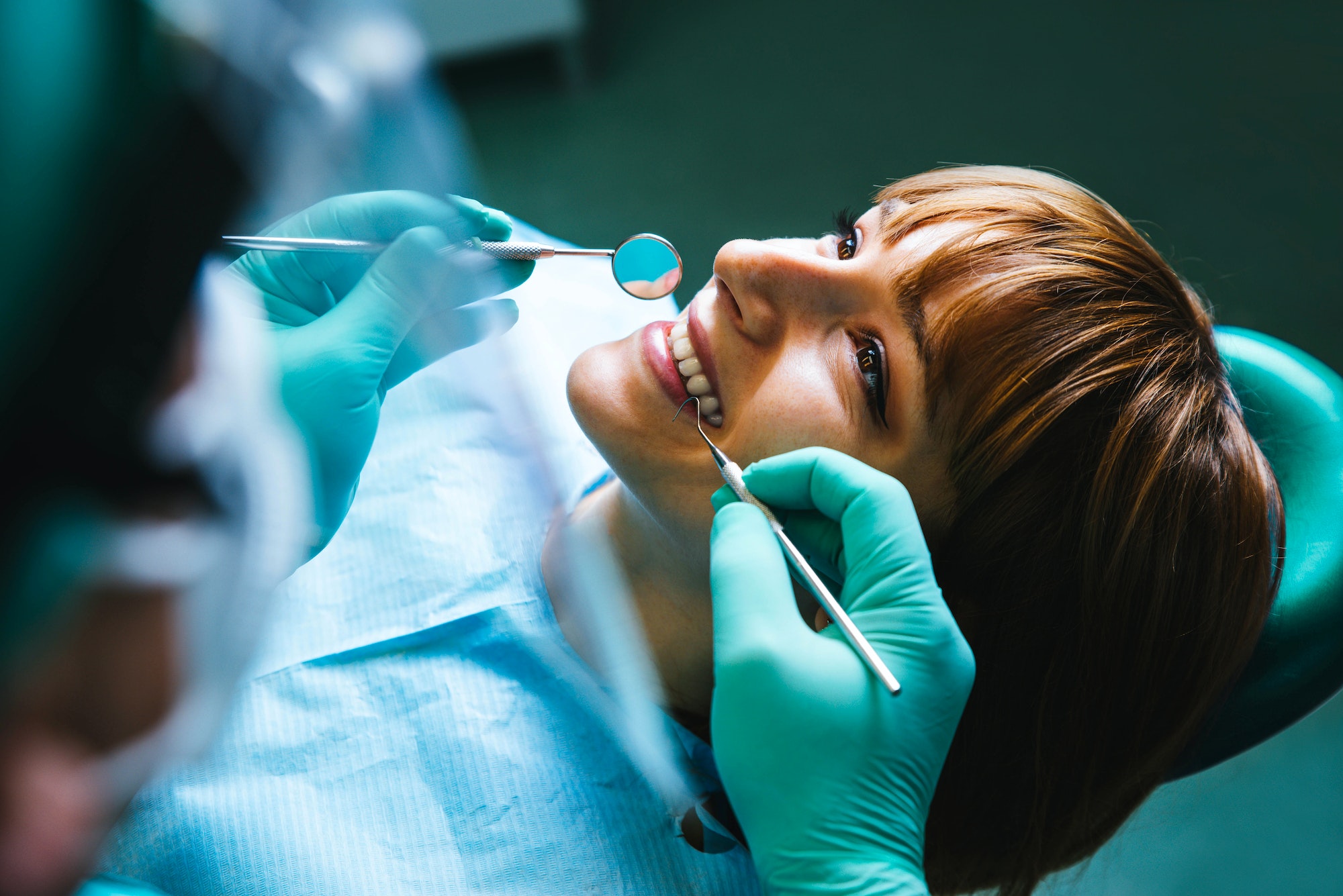 Smiling woman mouth under treatment at dental clinic - Oral healthcare concept